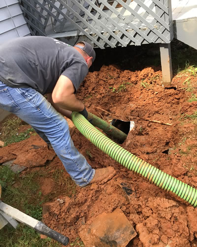 Prime Septic Technician Accessing Septic Tank Underneath Deck At A Home In Williamston South Carolina.